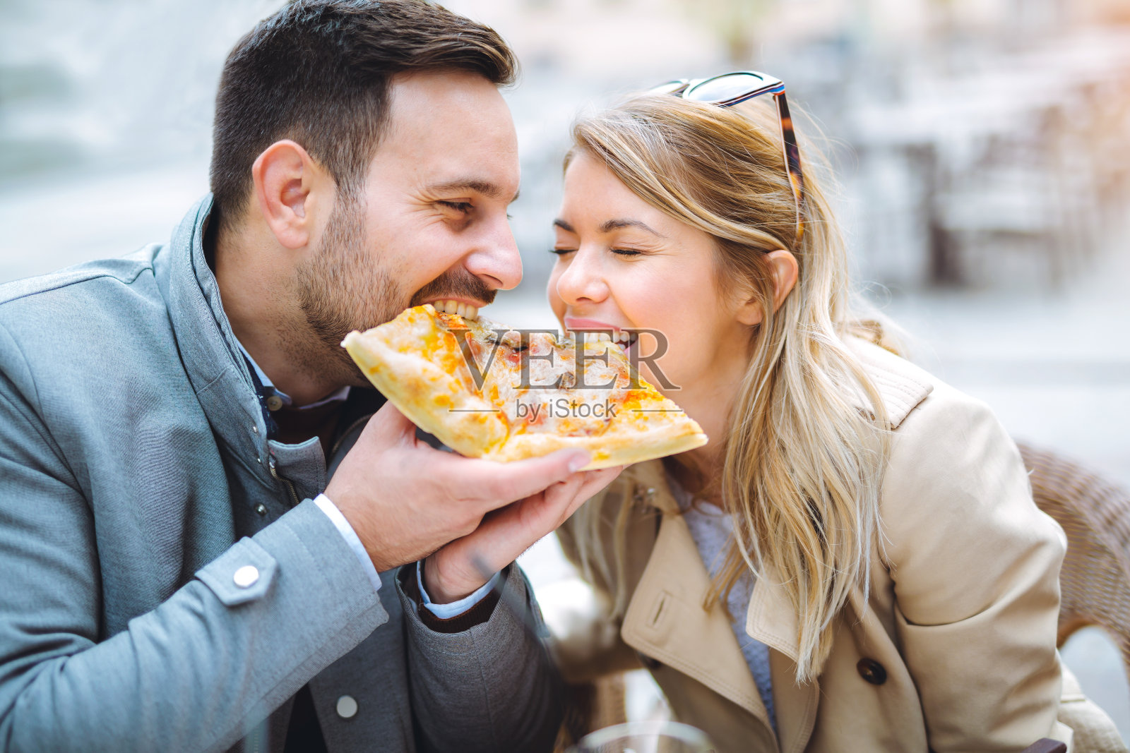 一对情侣在餐厅吃披萨。照片摄影图片