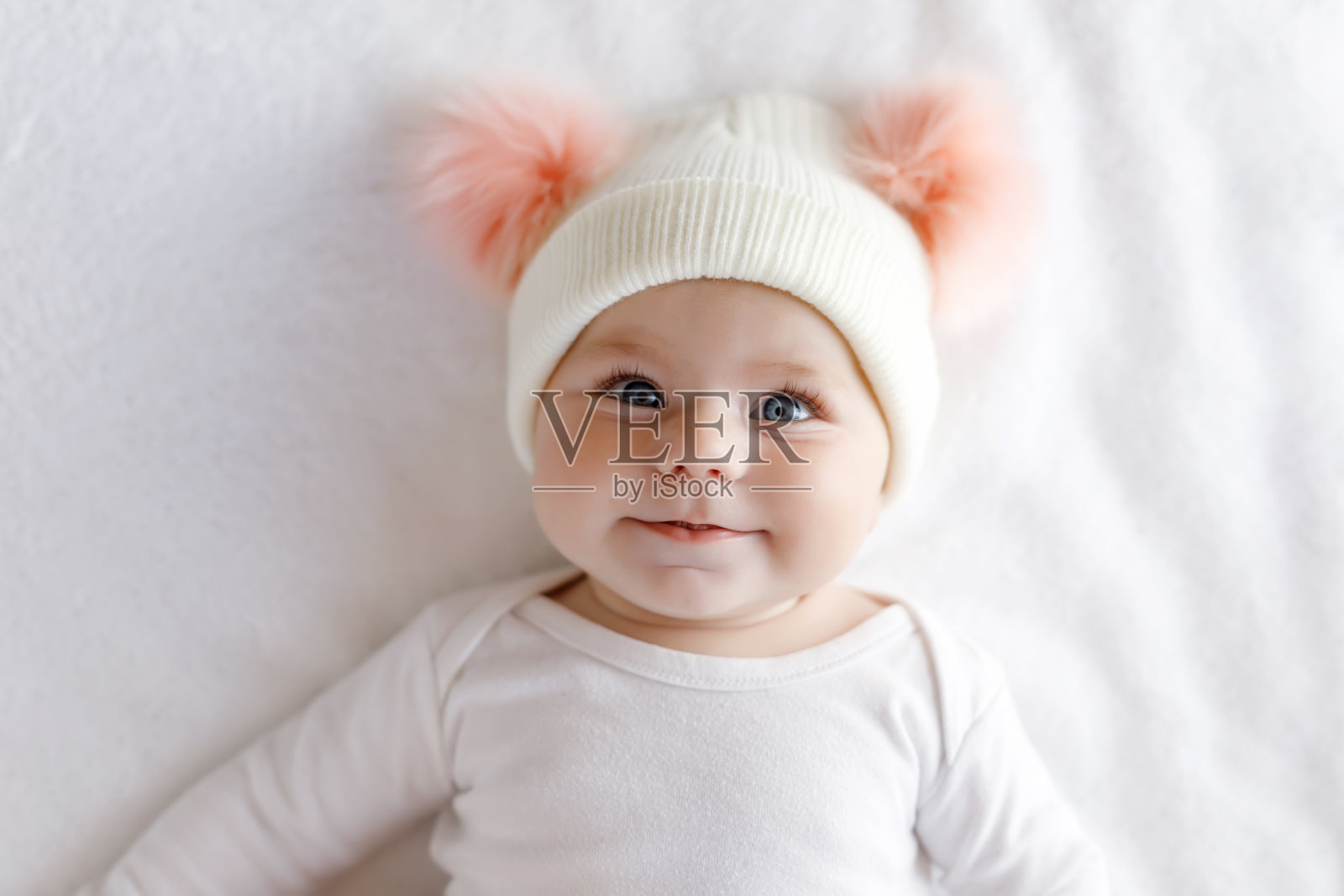 可爱可爱的宝宝和温暖的白色和粉红色的帽子和可爱的球照片摄影图片
