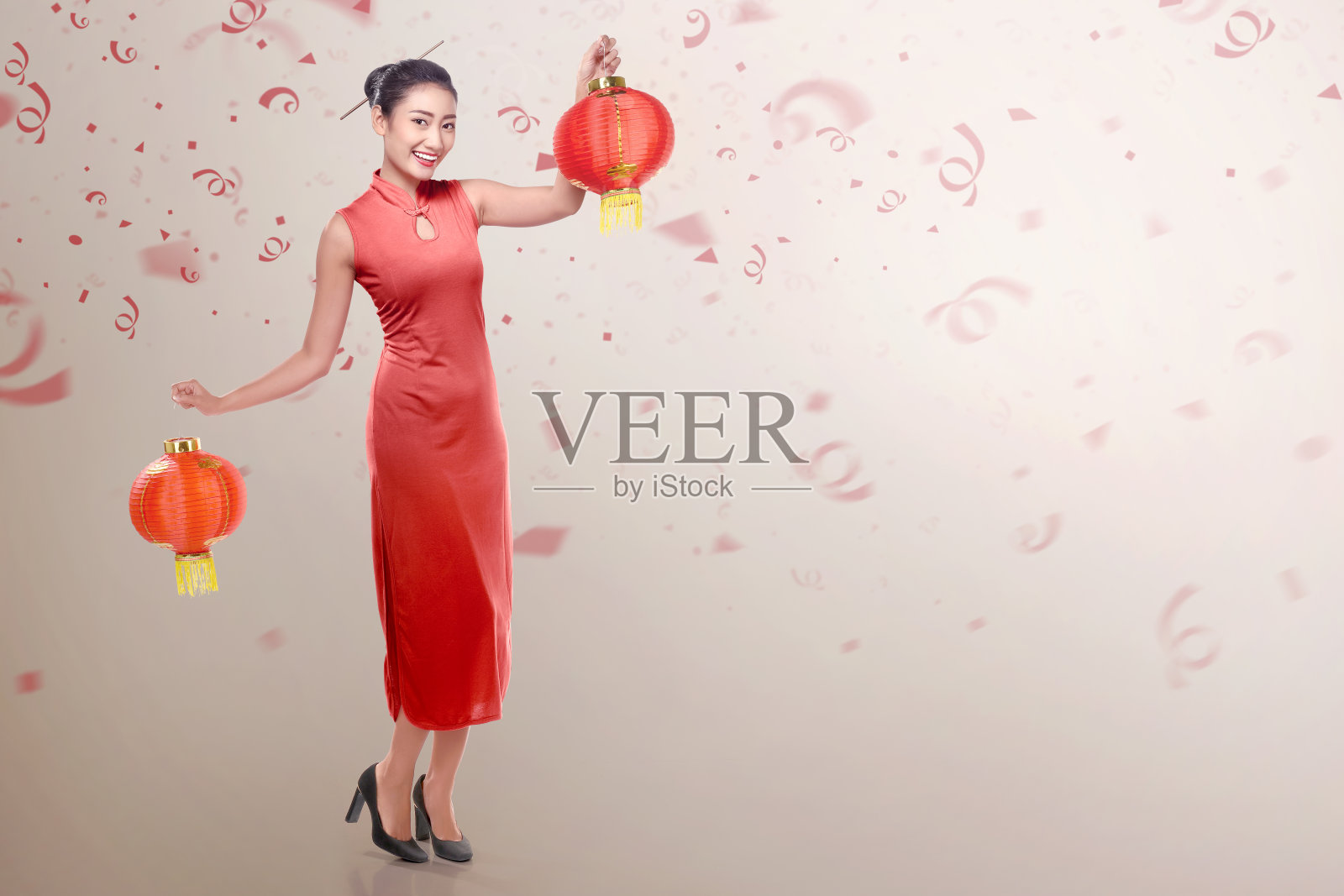 年轻的中国妇女穿着旗袍，手持中国灯笼照片摄影图片