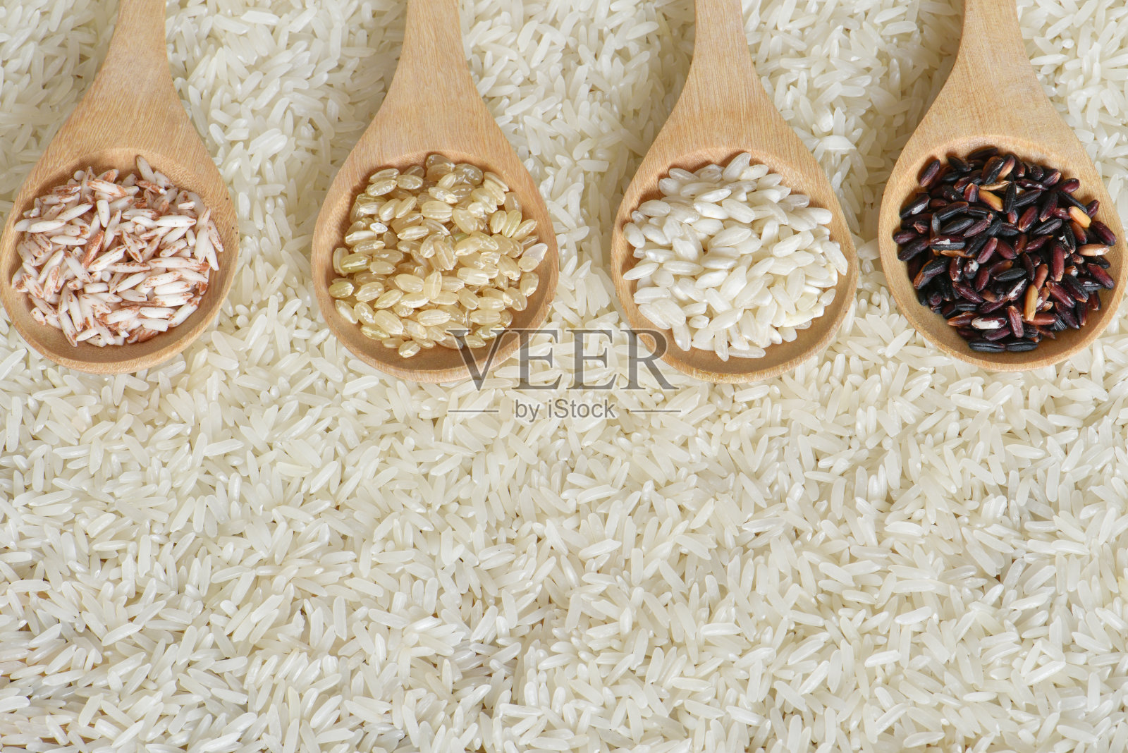 俯视图不同的大米在木勺上以茉莉花米为背景，各种大米有机在木勺上收集照片摄影图片