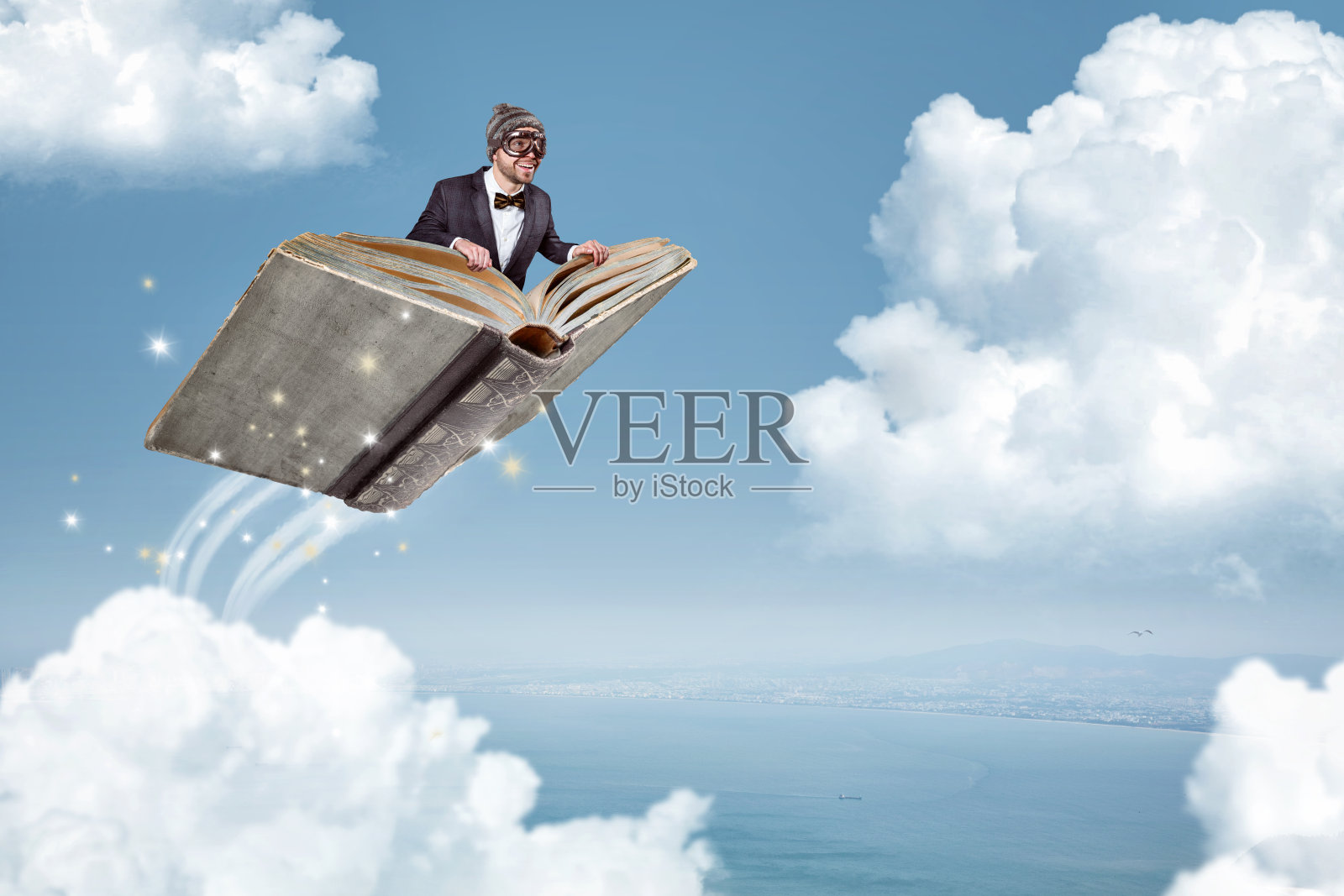 一个人在一本书上飞过云层照片摄影图片