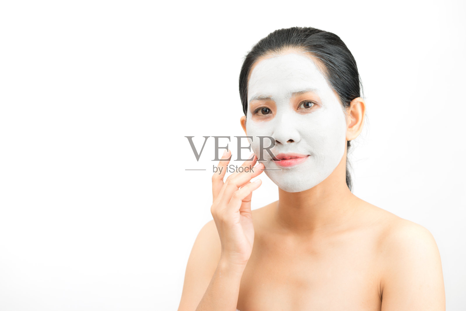 年轻女子粘土面膜脱皮自然与净化面膜在她的脸上在白色的背景照片摄影图片
