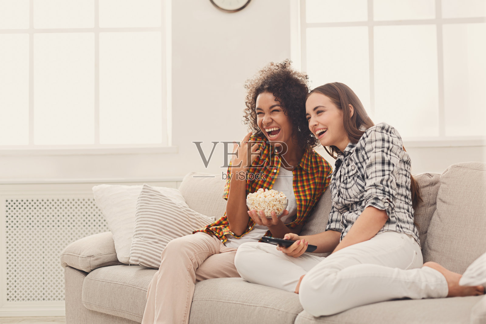 微笑的年轻女子在家里看电视照片摄影图片