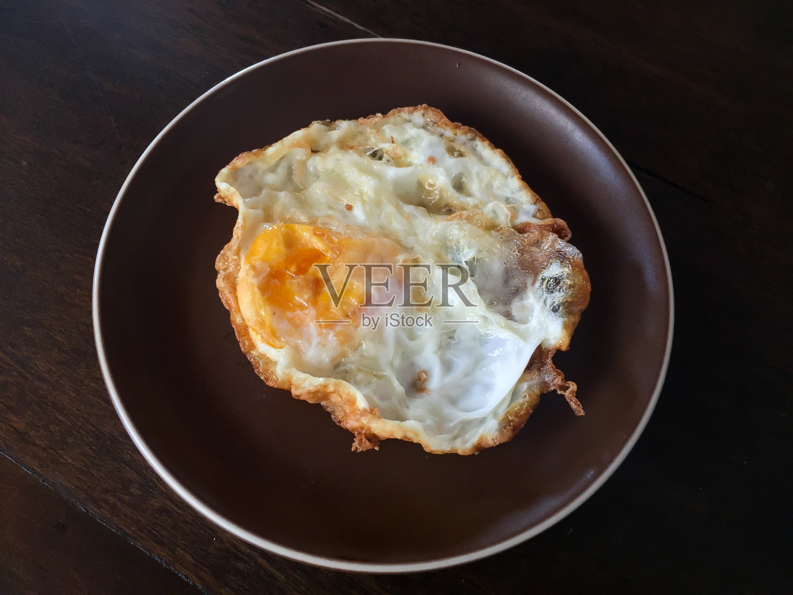 盘子上的煎蛋(木制背景)照片摄影图片
