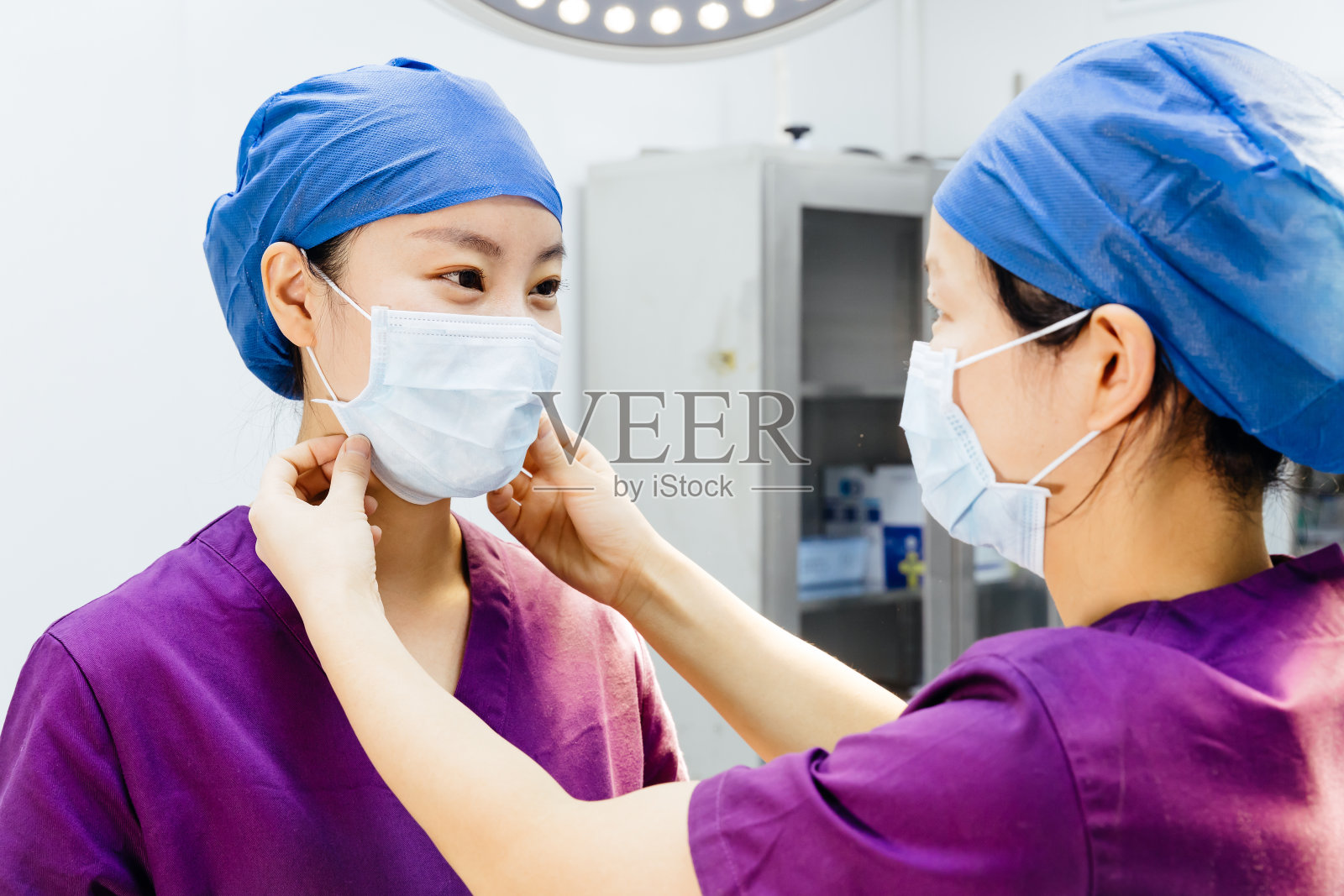 两名亚洲外科医生戴着口罩在中国上海的手术室里照片摄影图片