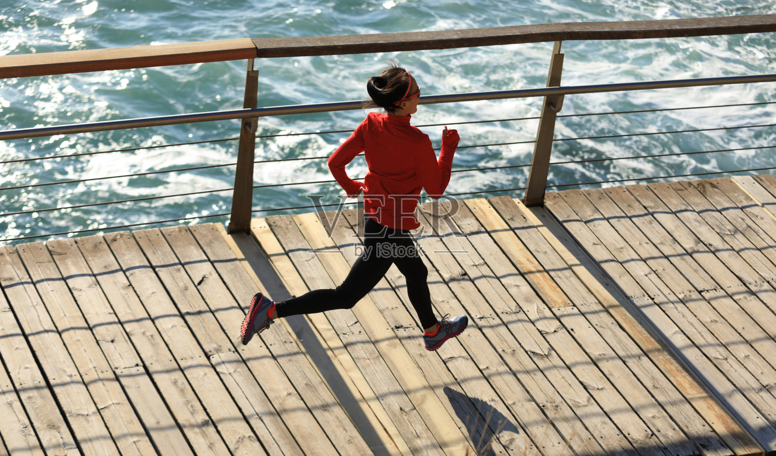 俯视图的运动健身女性跑步在海滨木板路照片摄影图片