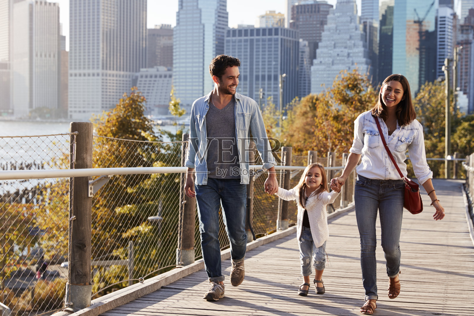年轻的家庭和女儿在人行桥上散步照片摄影图片
