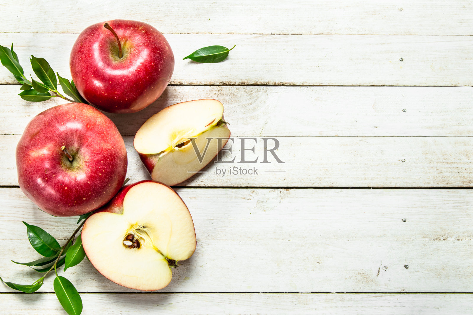 新鲜的带叶子的红苹果。照片摄影图片