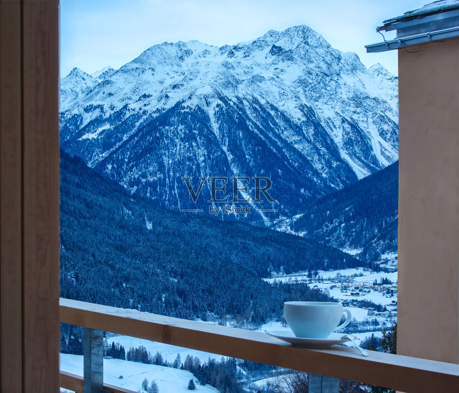 黄昏时分，在阳台栏杆上喝杯茶。背景是恩加丁山谷。古尔达，下恩加丁，格劳宾登，瑞士。照片摄影图片