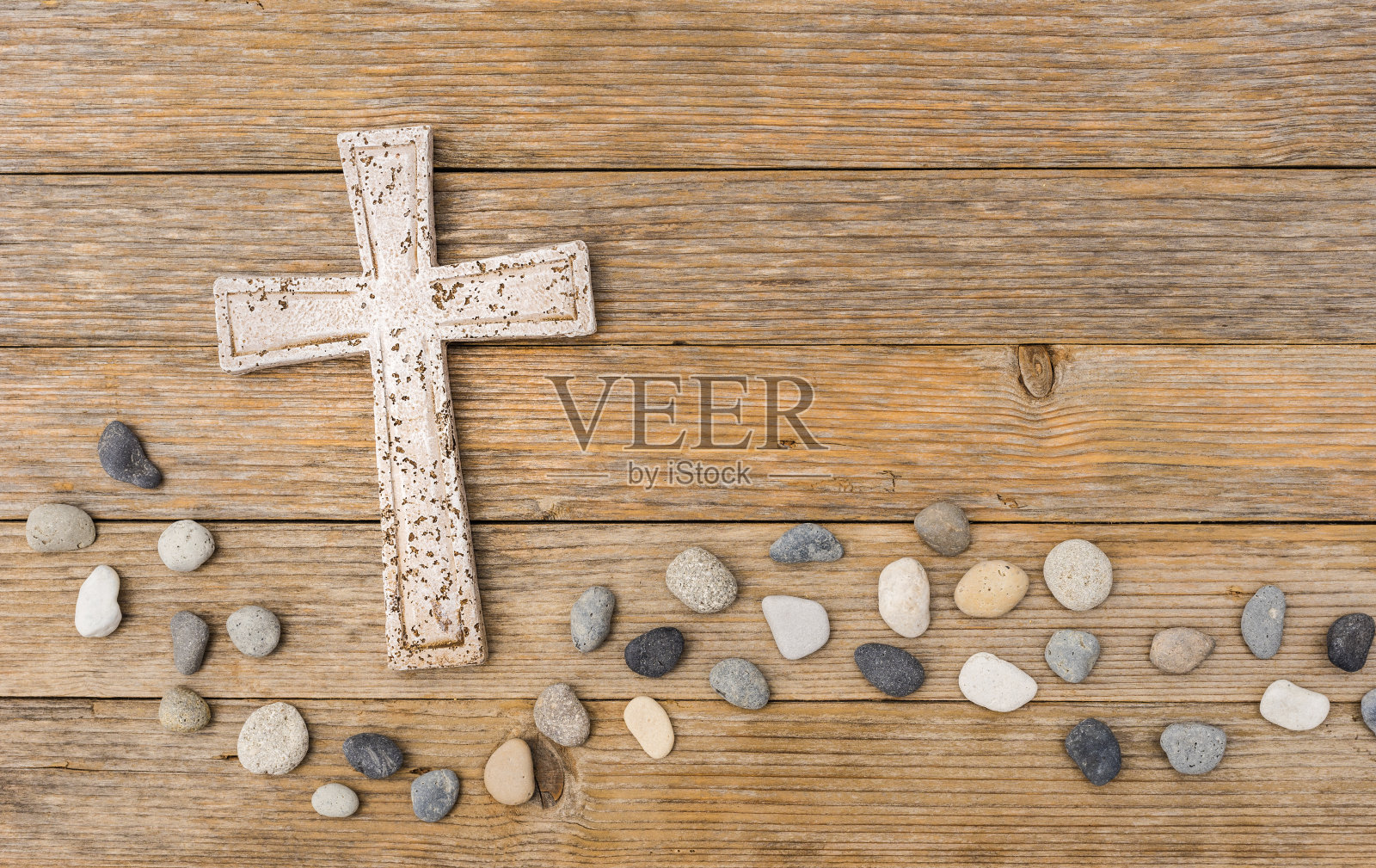 石头十字架与波浪卵石在木制的背景照片摄影图片