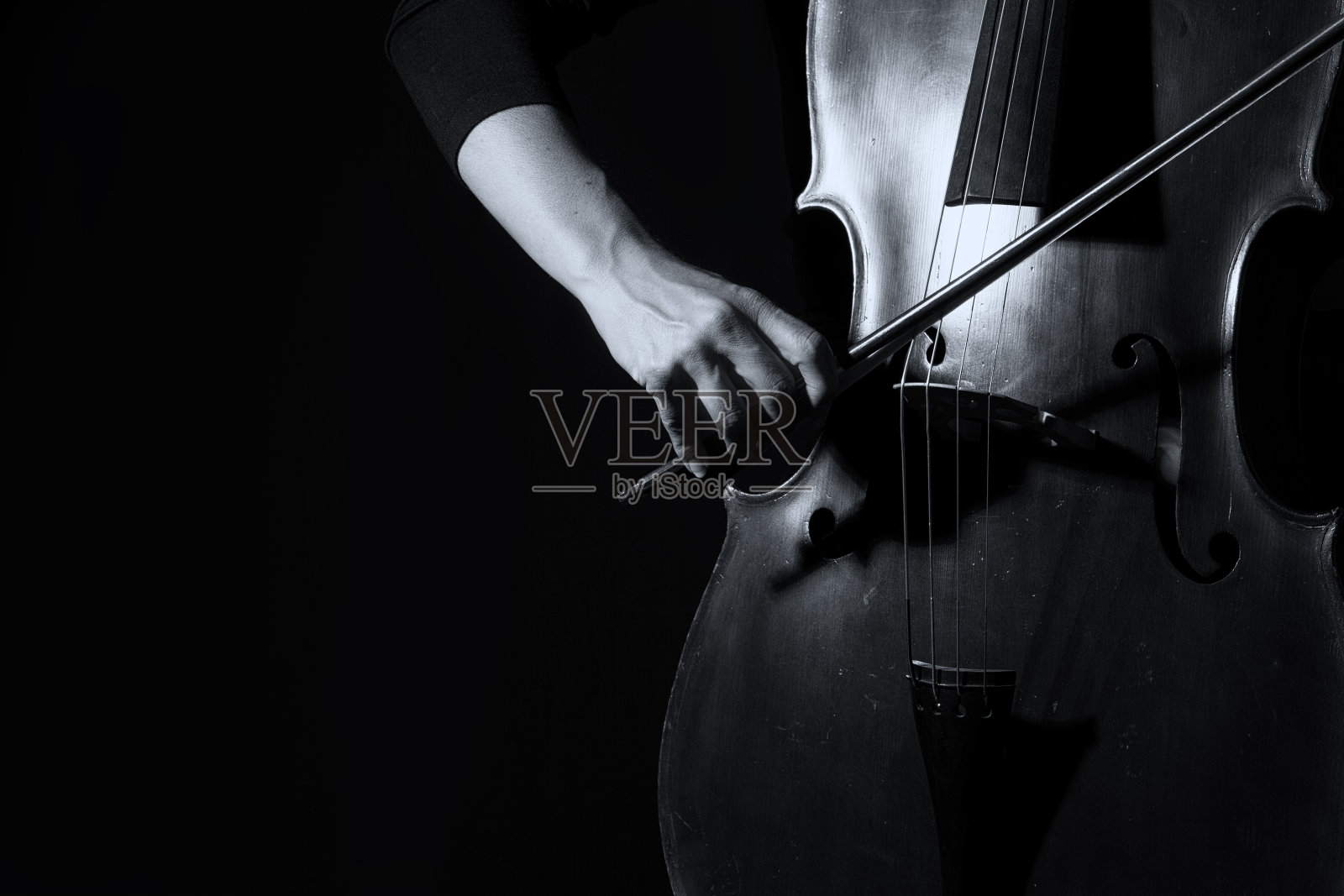 美丽的女人拿着大提琴与选择光在黑色礼服艺术转换照片摄影图片