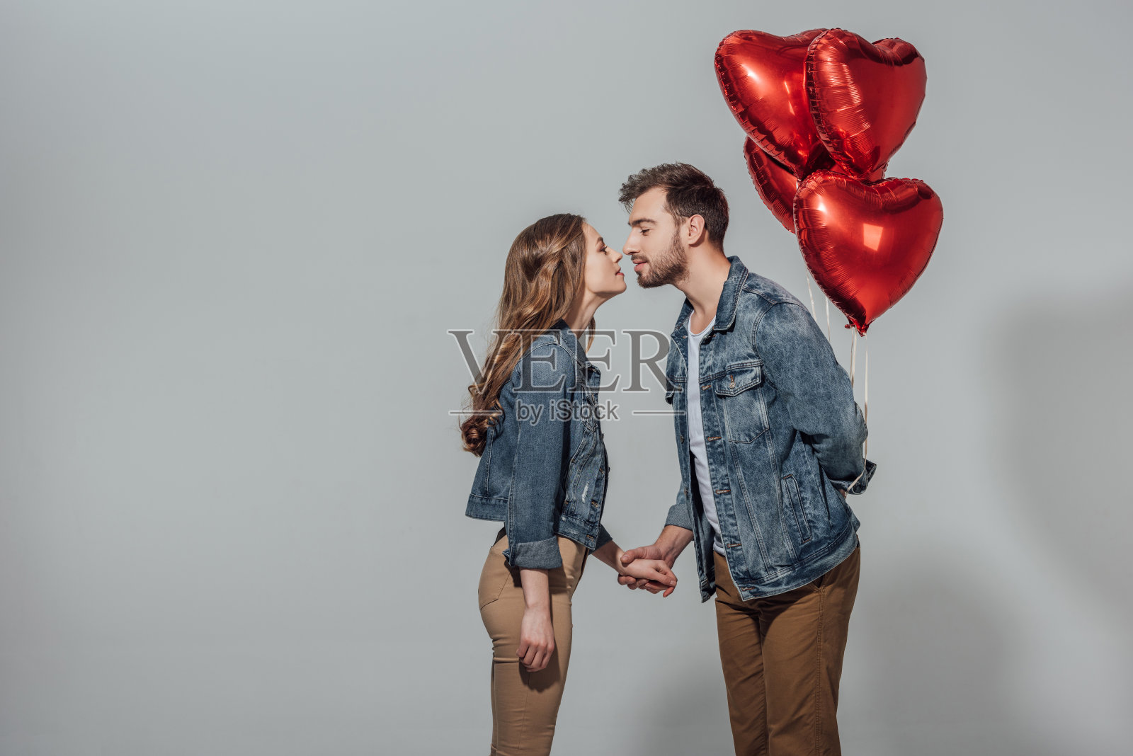 情侣们可以在男人拿着红心气球的时候接吻照片摄影图片