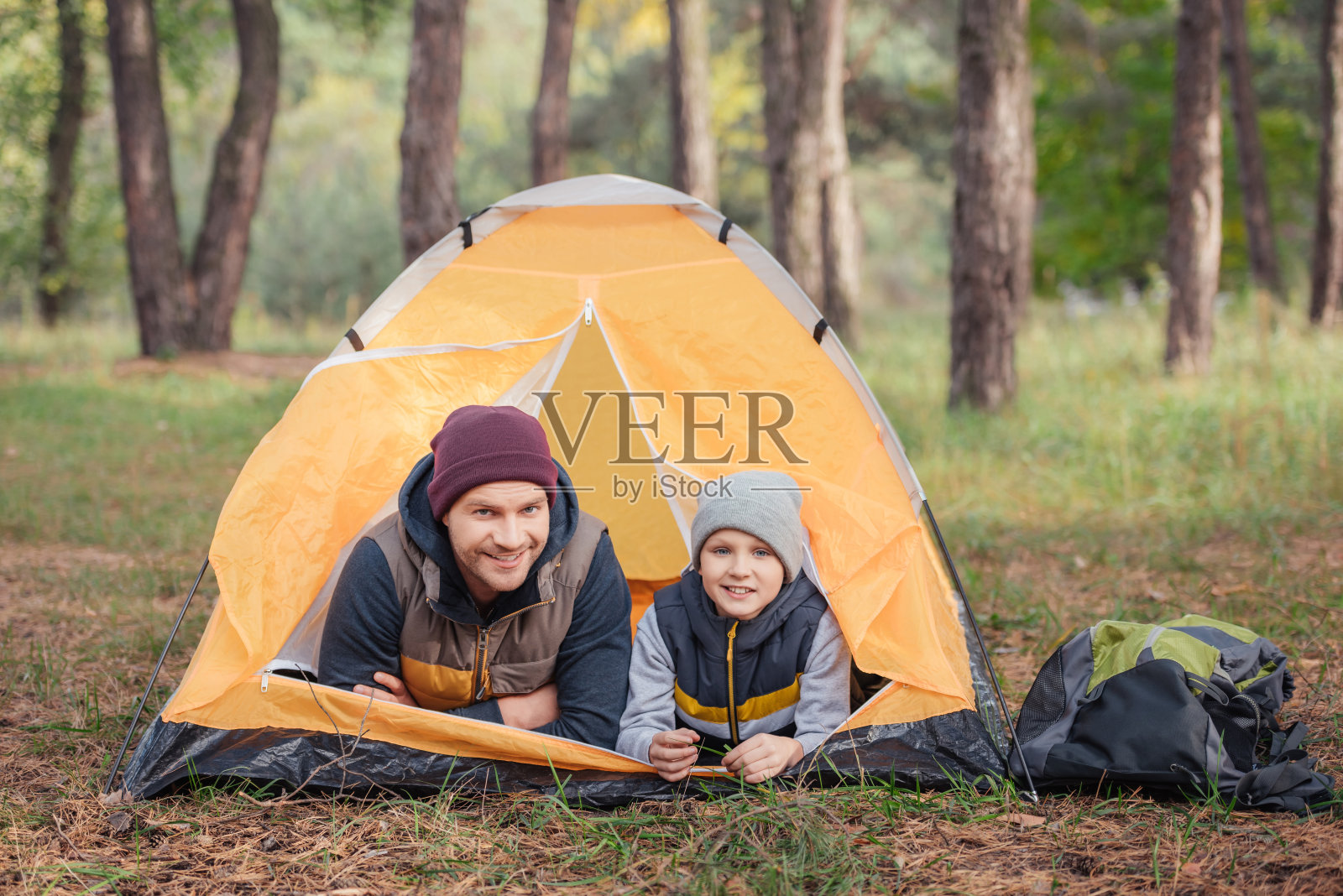 父亲和儿子躺在帐篷里照片摄影图片