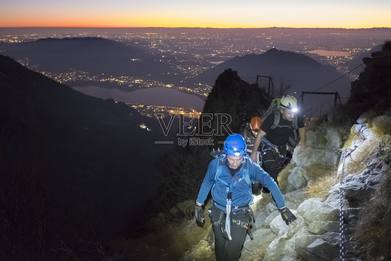 黄昏时分，一群登山队员在山上俯瞰城市照片摄影图片
