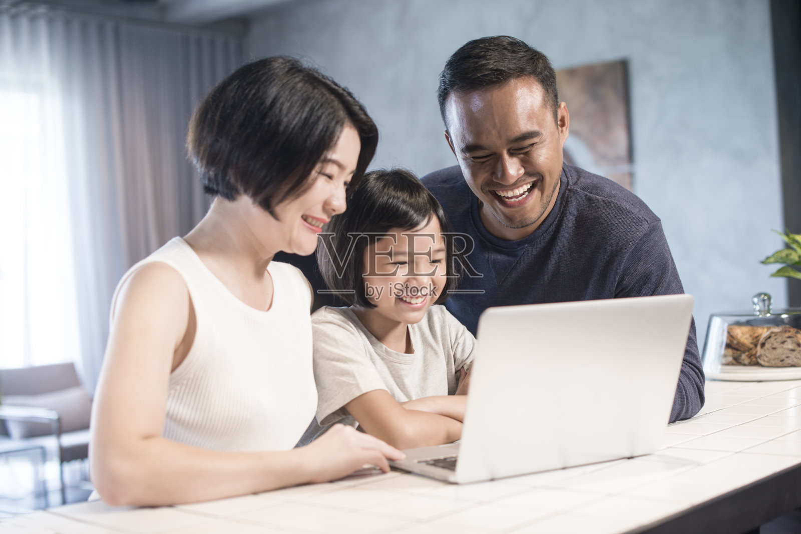 亚洲家庭一起看电脑。照片摄影图片