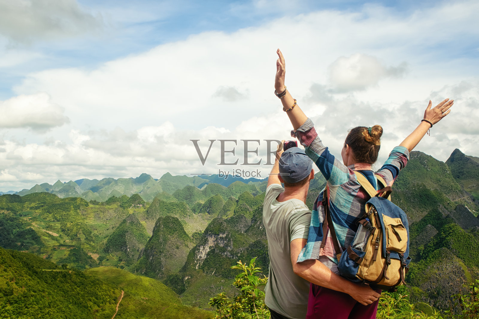 一对游客在喀斯特山脉背景下自拍。照片摄影图片