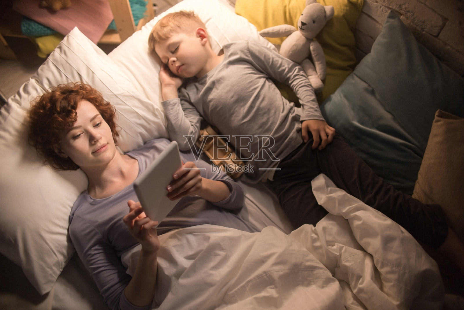 母亲和儿子在床上读故事照片摄影图片