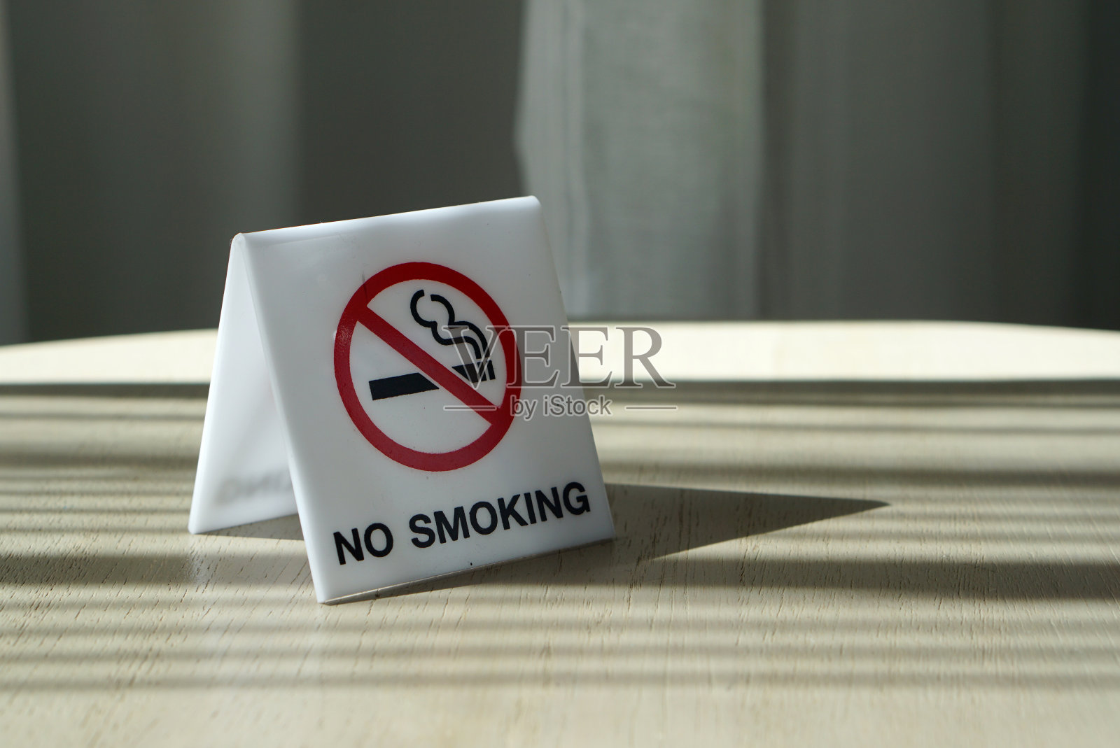 白色丙烯酸木桌上的通用禁止吸烟标志照片摄影图片