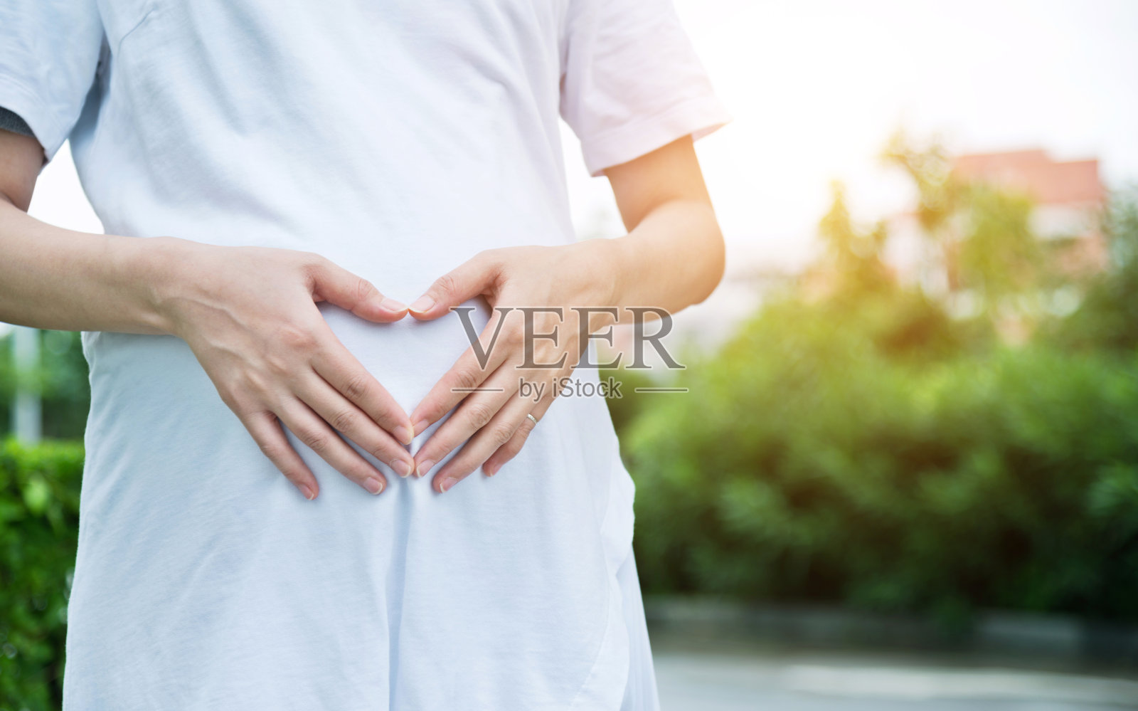 一个孕妇在肚子上摆出心形的姿势照片摄影图片