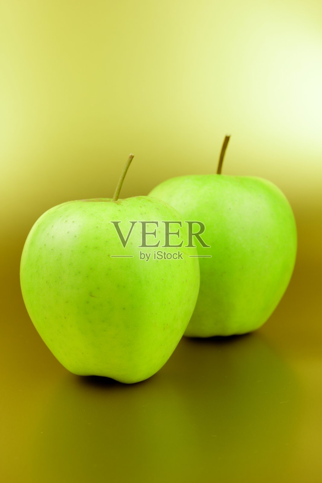 绿苹果在金色的背景，绿水果在黄色的背景，苹果流行艺术，维生素，健康的生活方式，素食主义，极简主义照片摄影图片