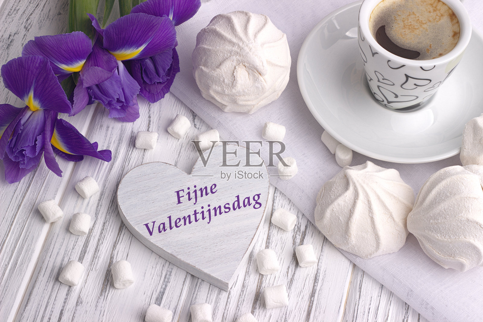 静物与一杯咖啡，棉花糖，风鸢尾花，花心形标志与字母在荷兰在白色木制背景上的情人节快乐。照片摄影图片