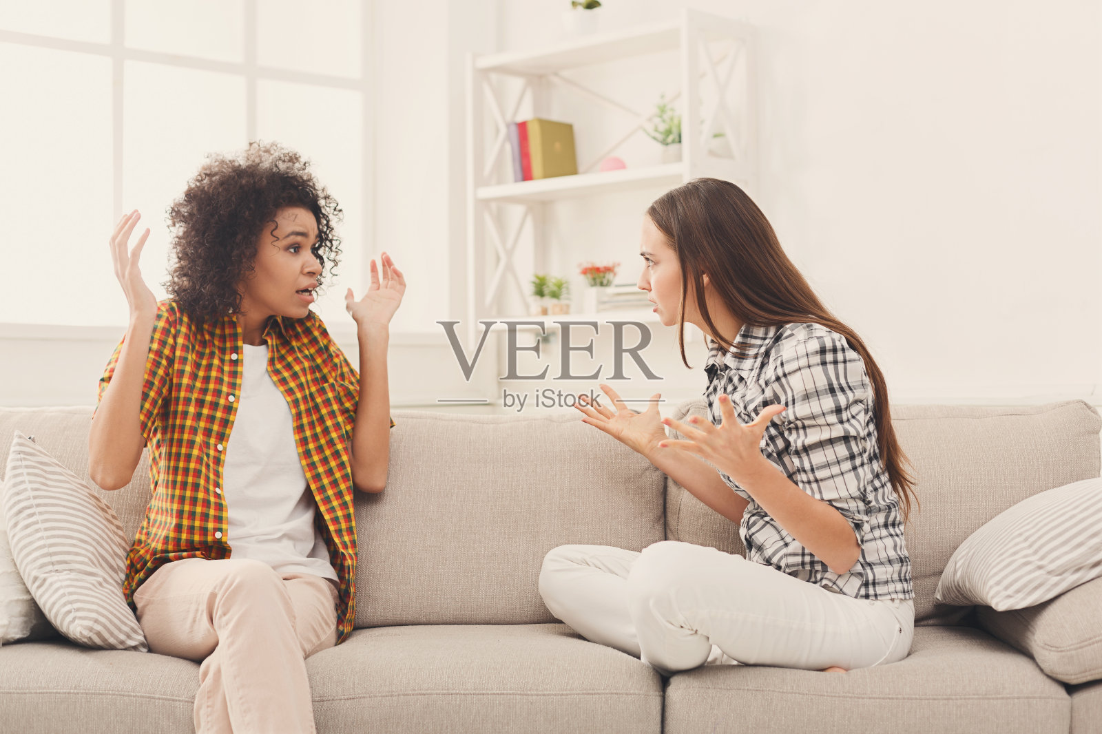 两个女性朋友坐在沙发上争吵照片摄影图片