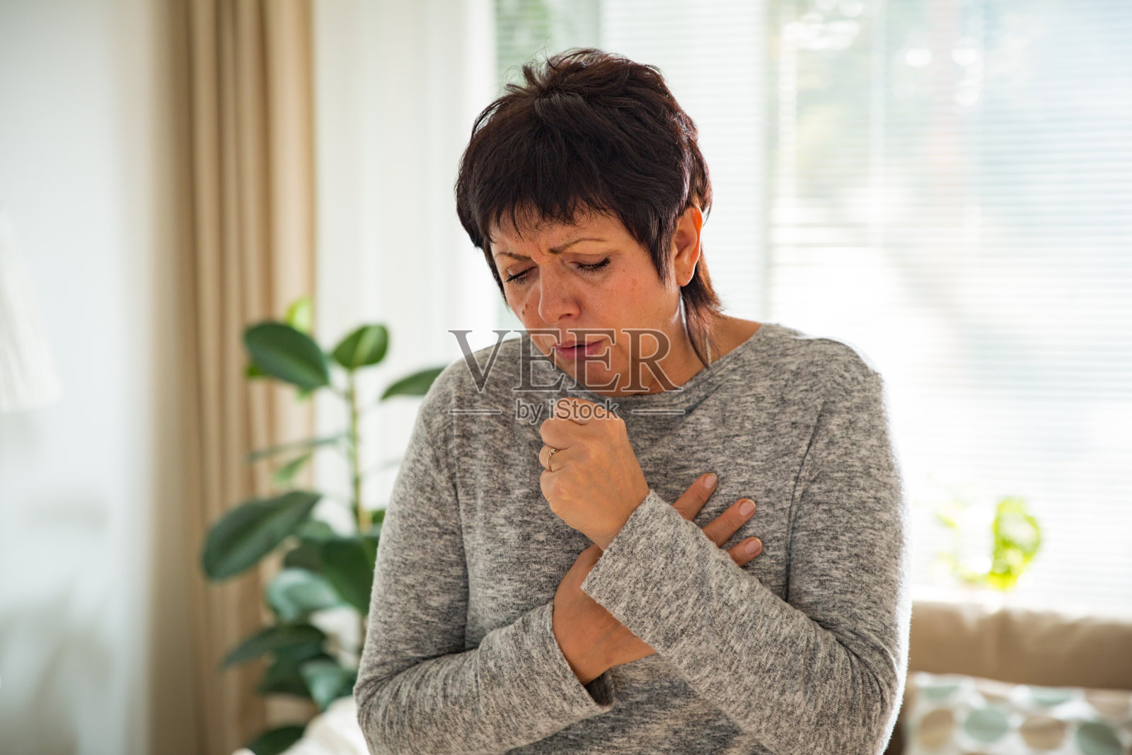 喉咙痛的成熟女人照片摄影图片