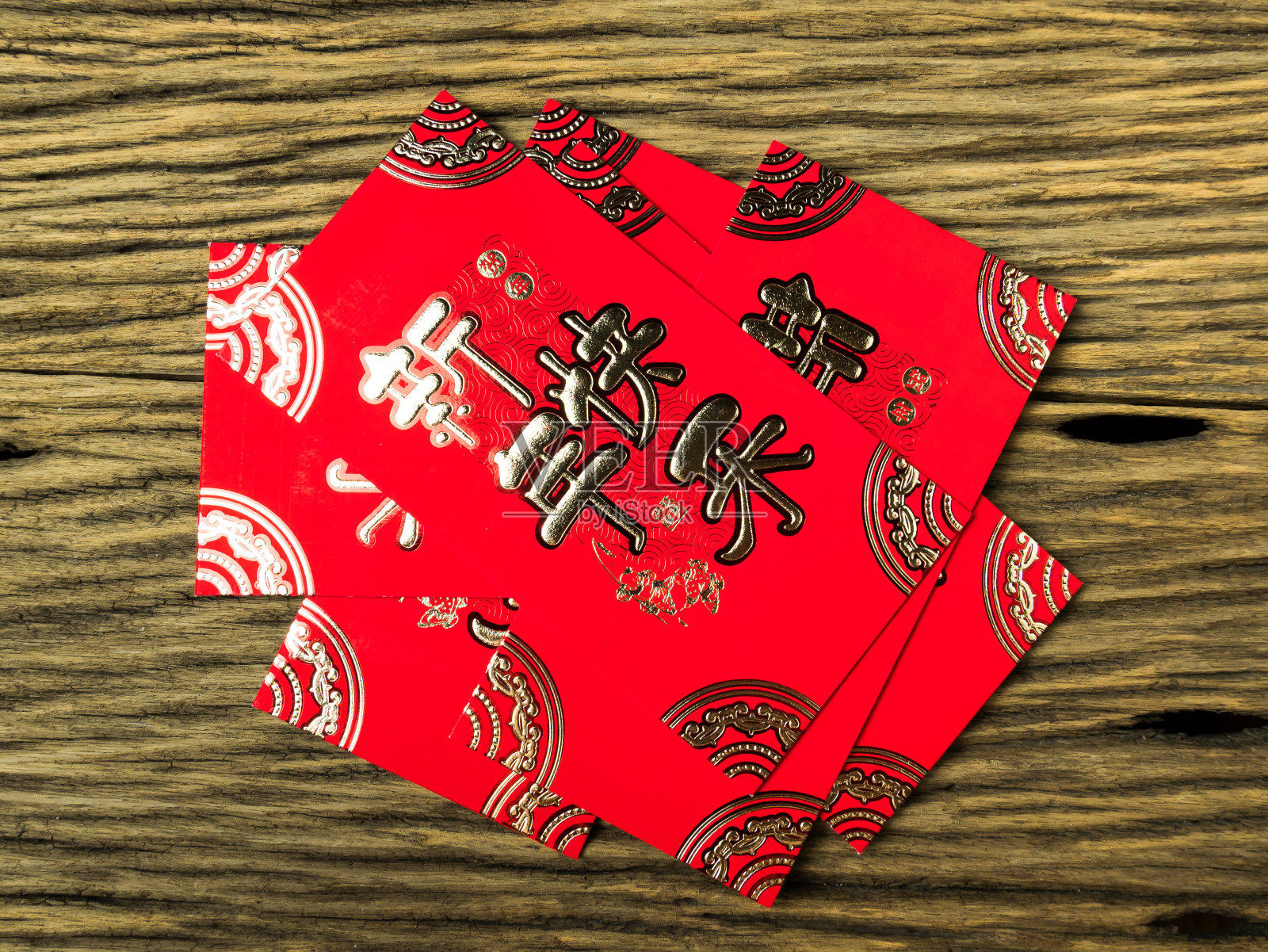 木制背景的红色信封，以二月作为春节礼物。信封上的中文文字寓意春节快乐照片摄影图片