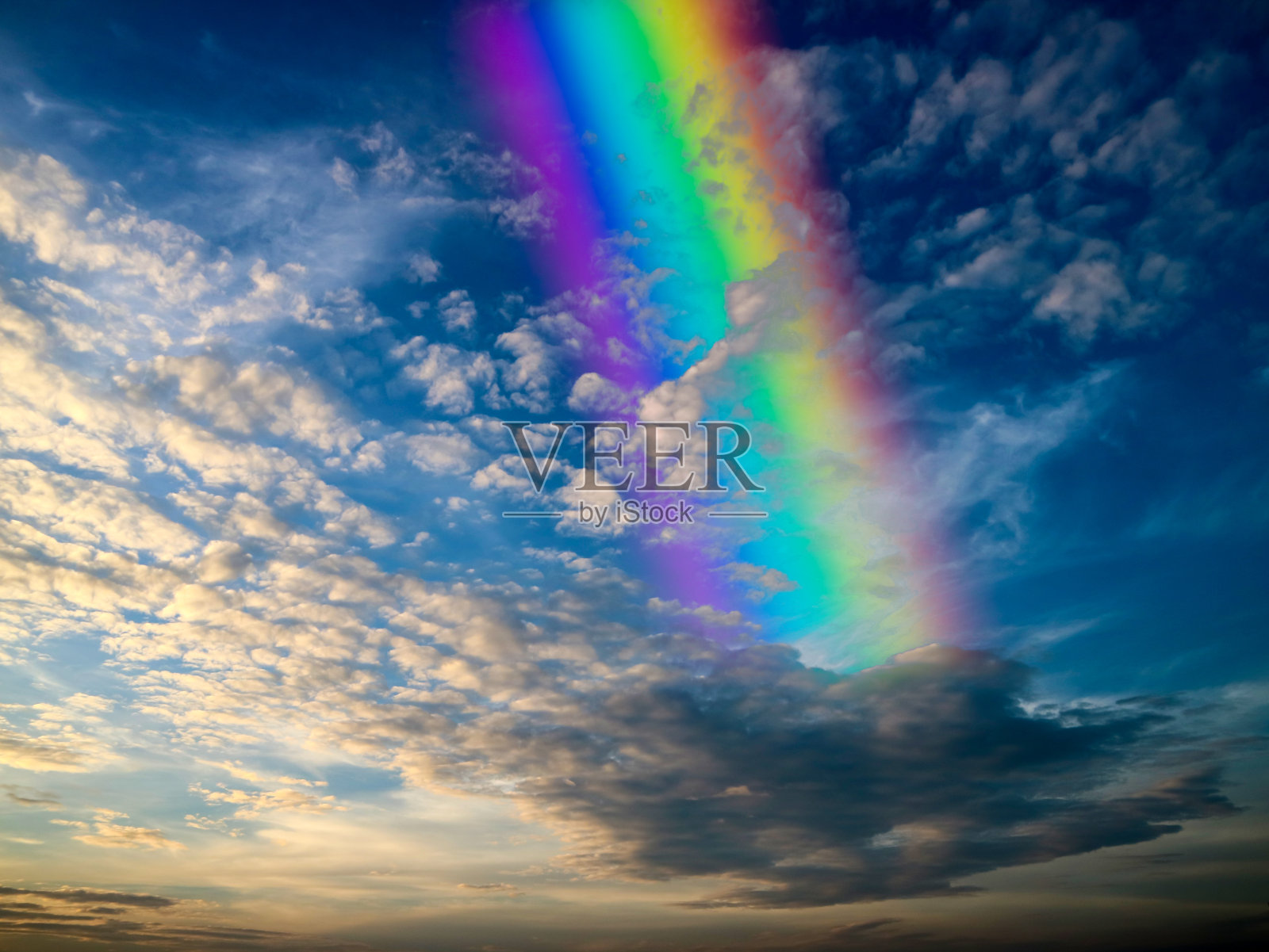 彩虹背铺云和夕阳的光照片摄影图片