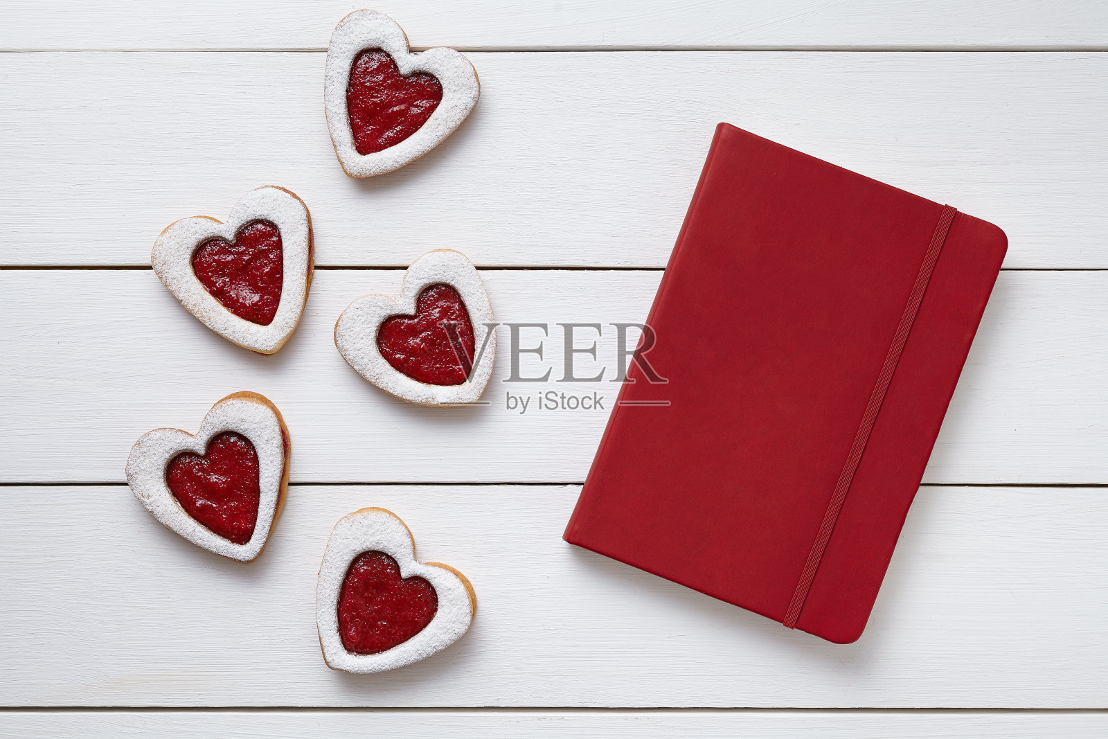 心形的饼干与空白的红色笔记本，构成白色照片摄影图片