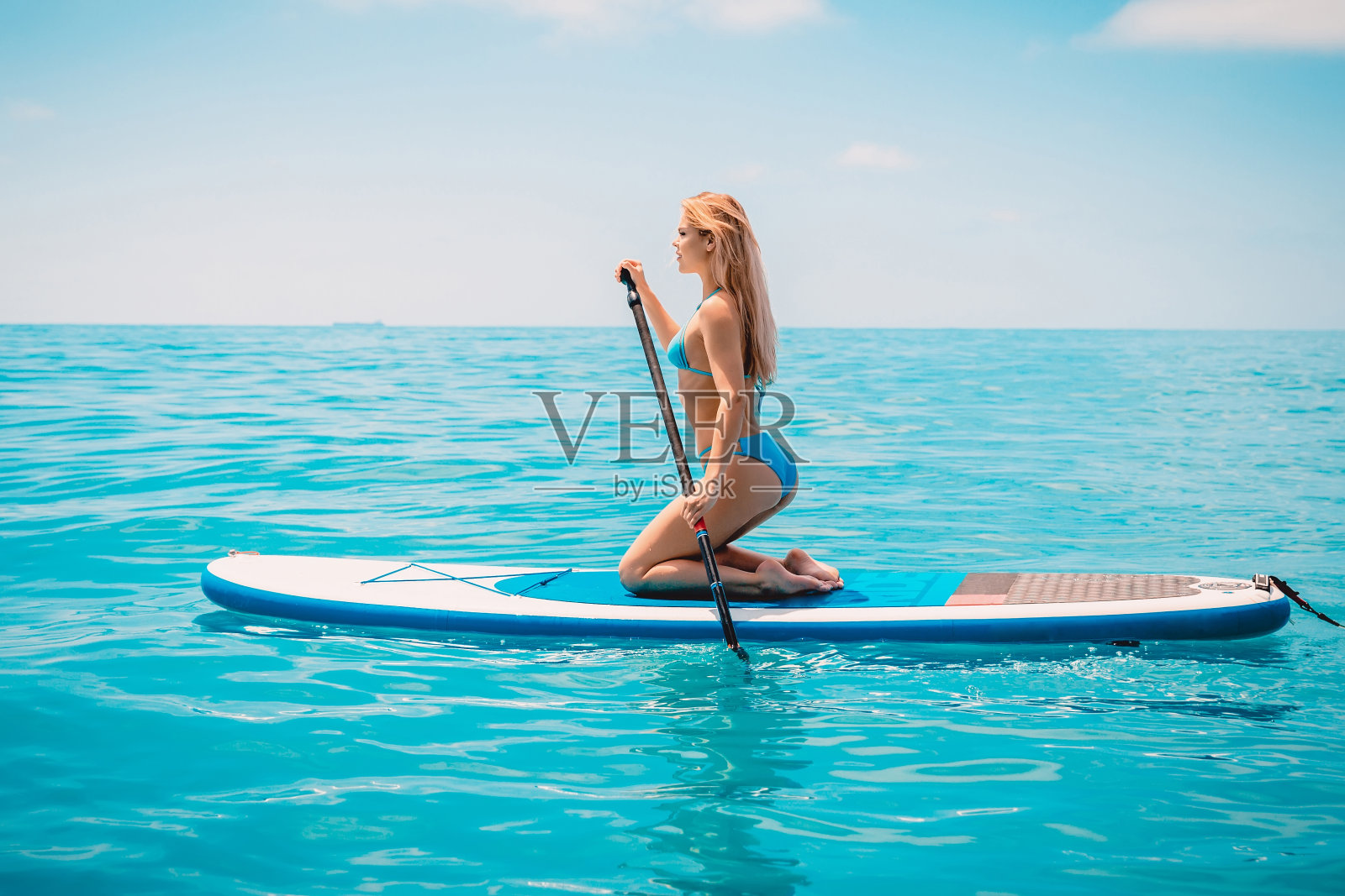 一个有着完美身体的美丽女子在一个阳光明媚的日子里练习划桨照片摄影图片