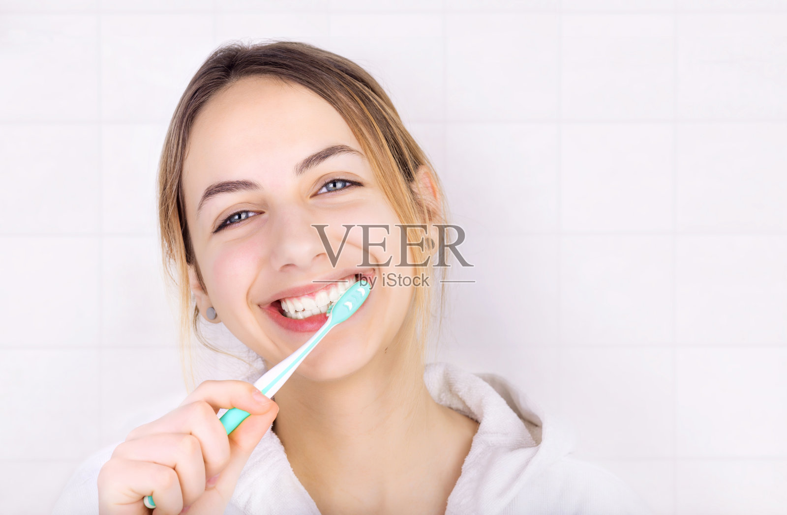 快乐的年轻女子正在刷牙。照片摄影图片