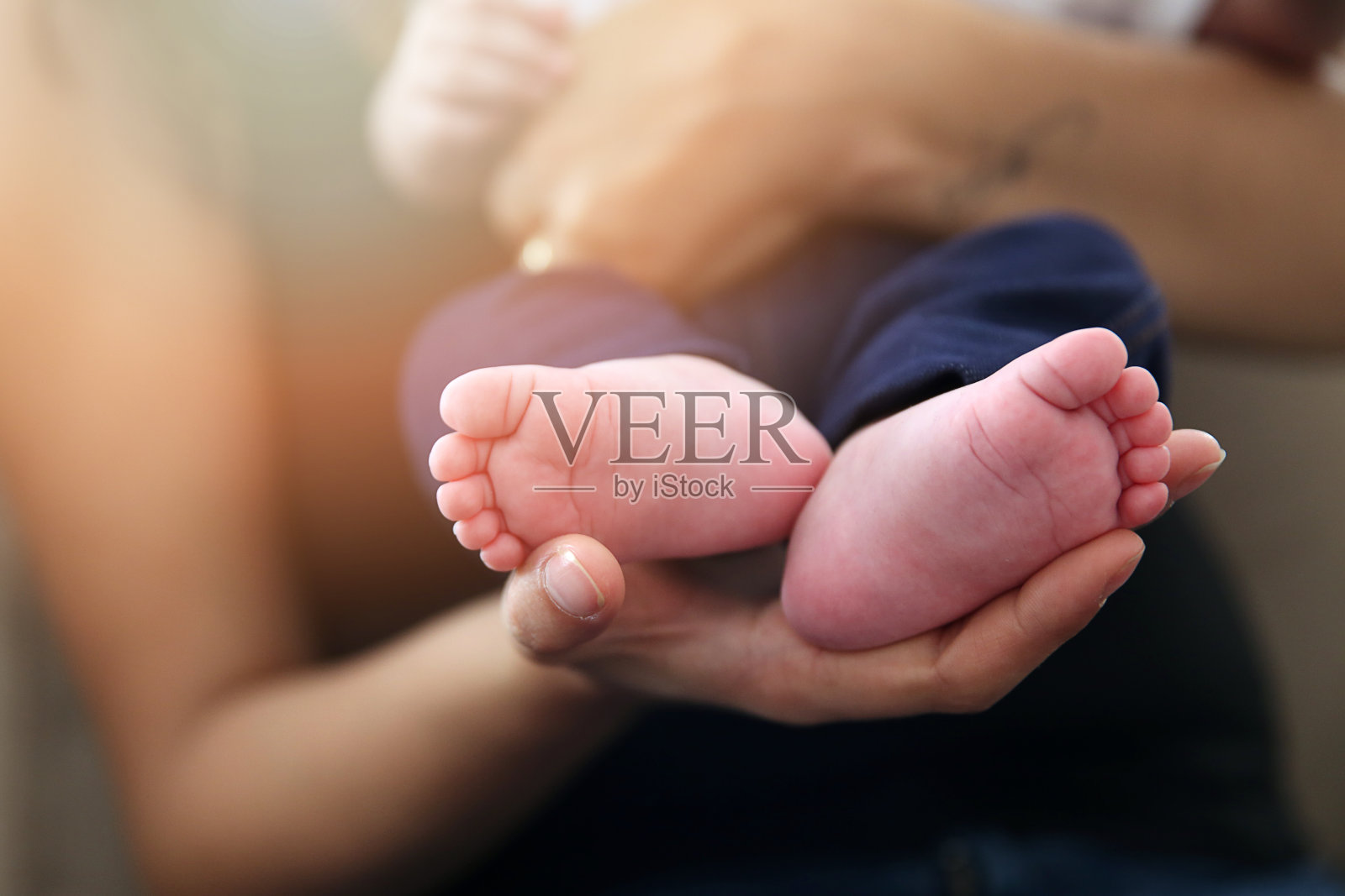 婴儿的脚在妈妈的手里。妈妈和孩子照片摄影图片