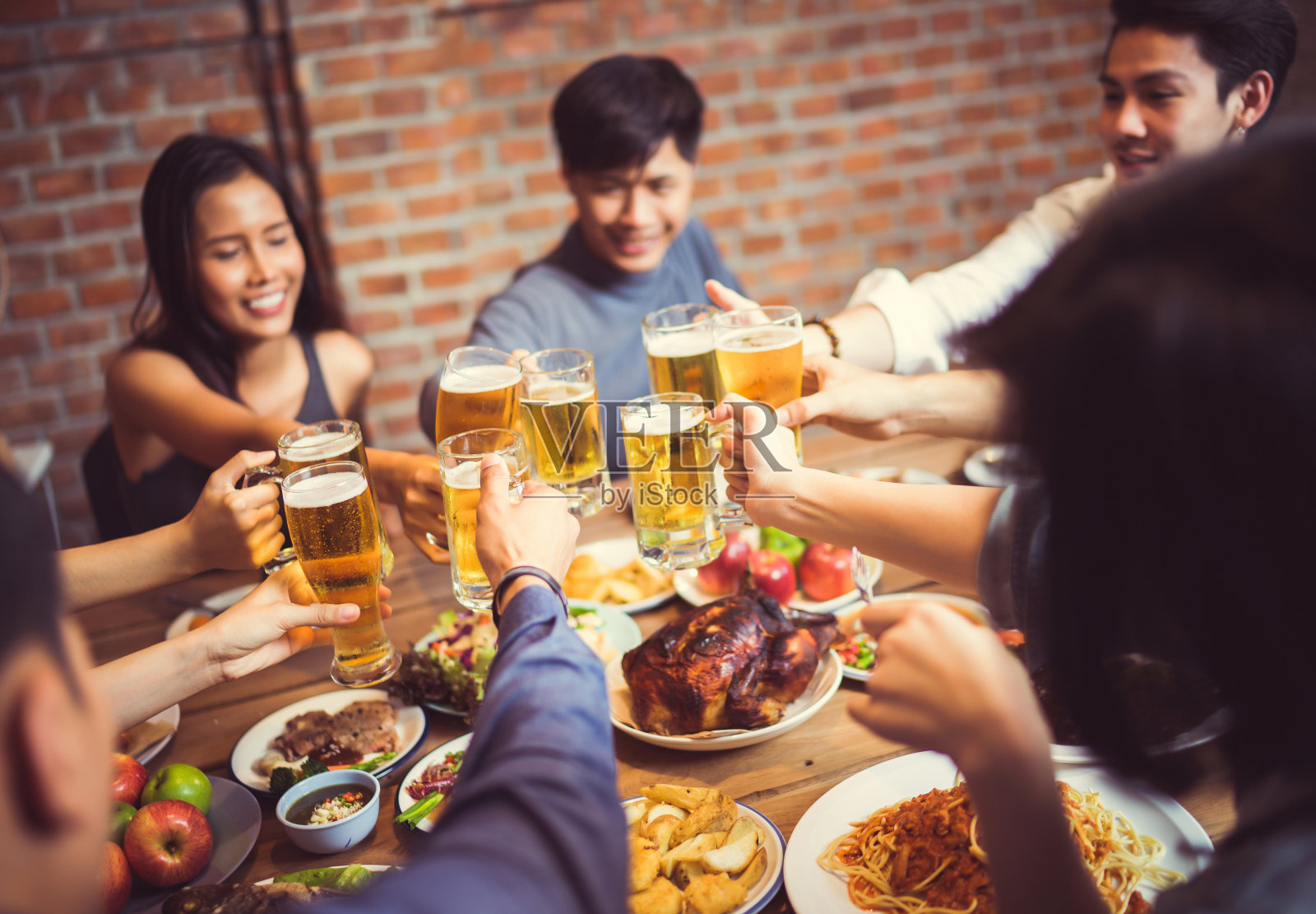 亚洲人庆祝节日，他们碰杯，啤酒和晚餐快乐。俯视图照片摄影图片