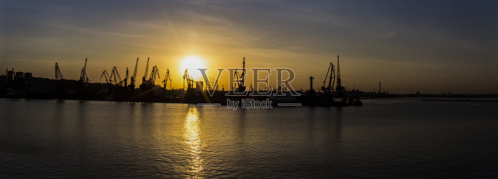 日落时分，敖德萨码头上的起重机照片摄影图片