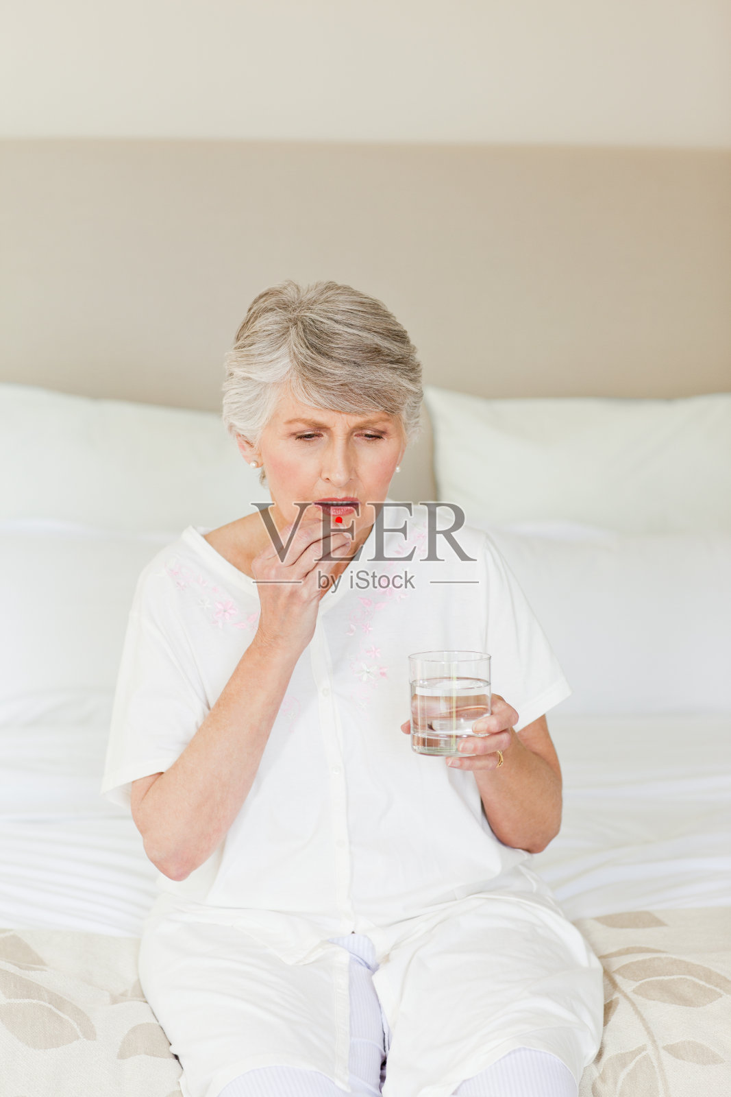 生病的年长妇女在吃药照片摄影图片