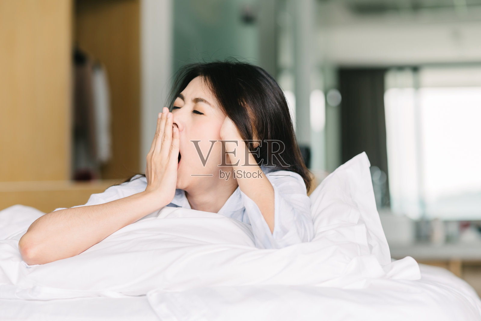 亚洲女人醒来后打哈欠照片摄影图片