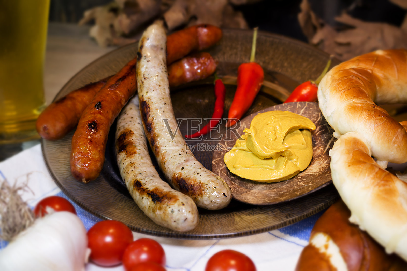 餐桌上的巴伐利亚白香肠和红香肠配芥末，巴伐利亚面包和椒盐卷饼。十月节的概念照片摄影图片