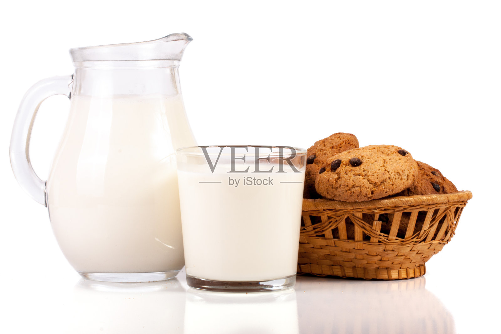 水壶和一杯牛奶和燕麦饼干放在柳条篮子孤立在白色背景照片摄影图片