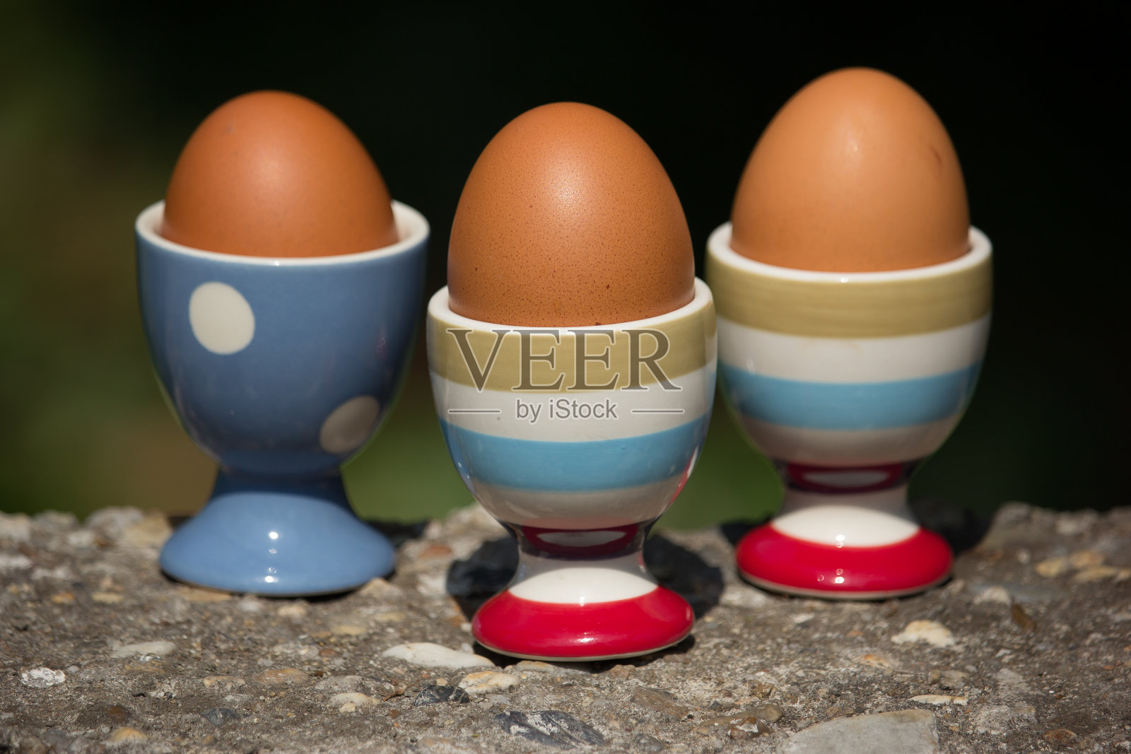 三个鸡蛋和杯子与黑暗模糊的背景照片摄影图片