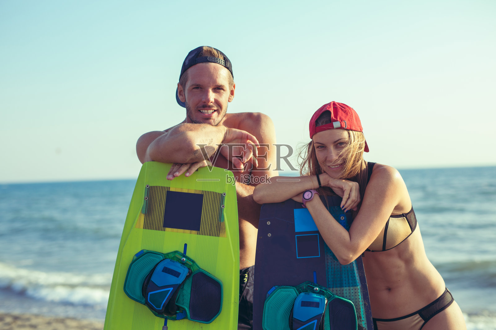 微笑的夫妇与风筝板在海滩上照片摄影图片
