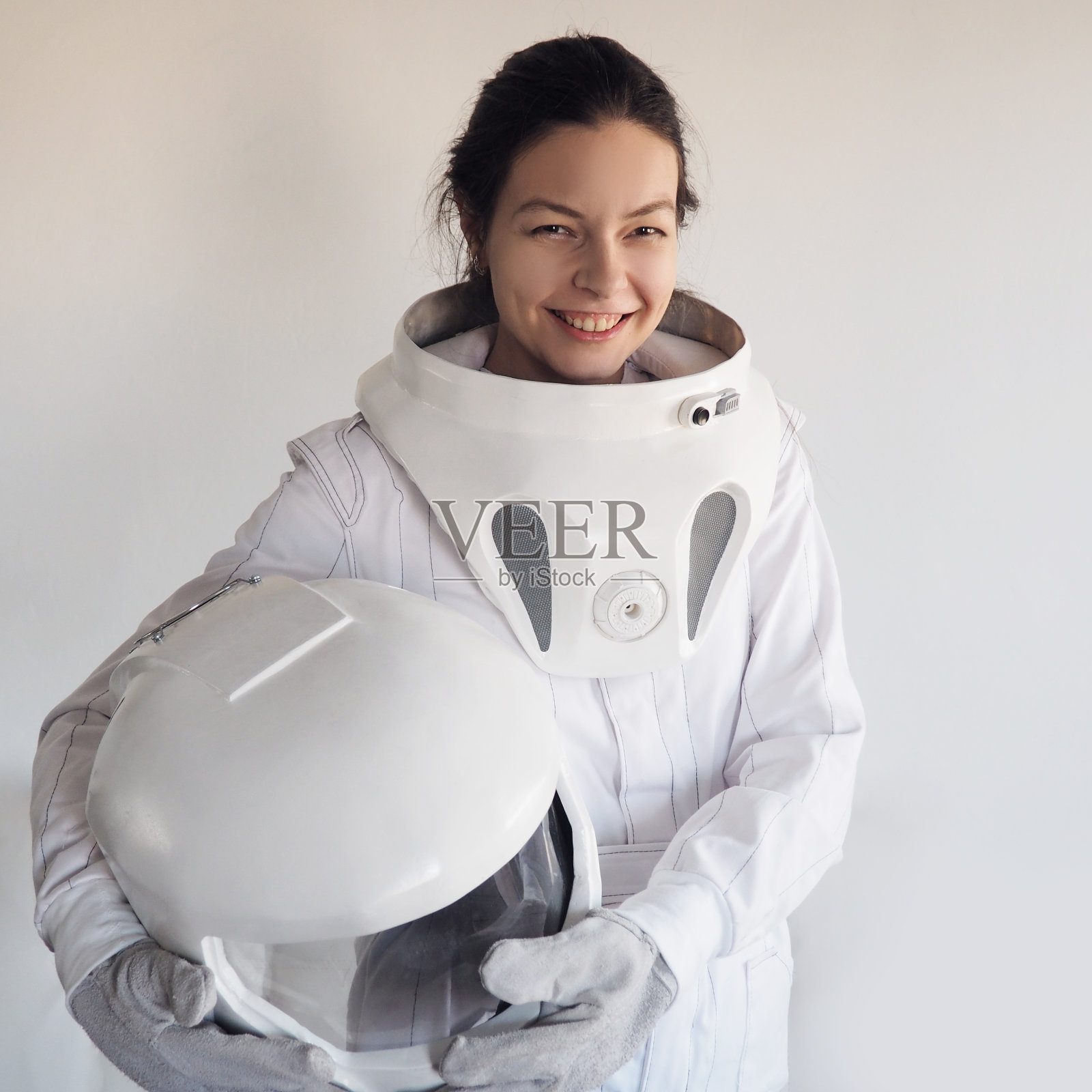 白色背景上的女宇航员。神奇的太空服。探索外层空间。照片摄影图片