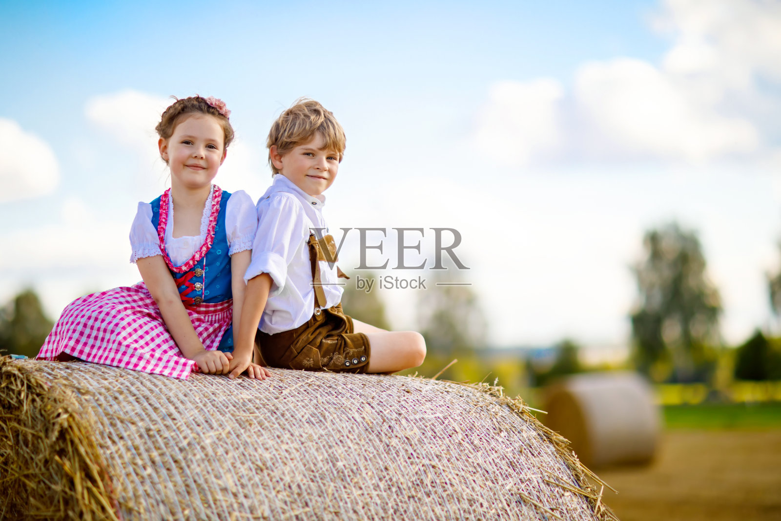 两个孩子，男孩和女孩穿着传统的巴伐利亚服装在麦田里照片摄影图片