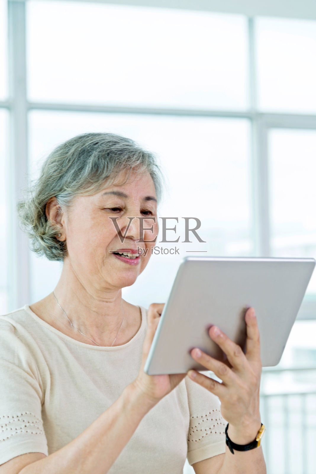 亚洲年长女性在家里使用数字平板电脑照片摄影图片