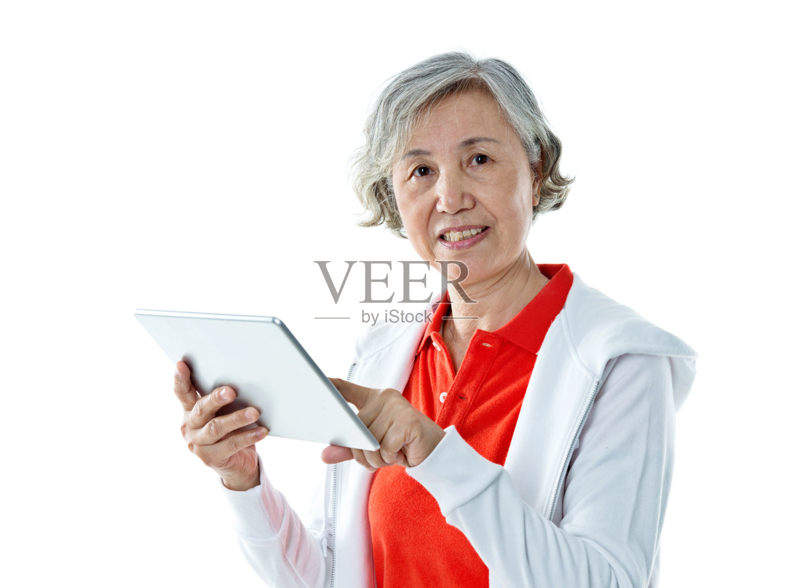 一名亚洲年长女性，手持数码平板电脑，背景是白色照片摄影图片