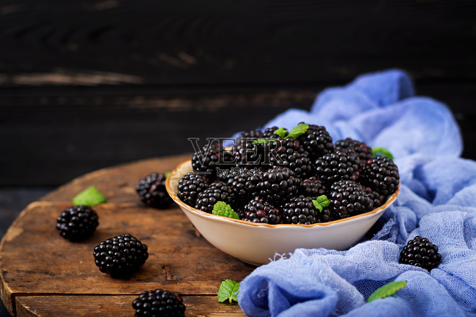 桌上放着夏天的浆果。健康生活理念，碗里的黑莓。照片摄影图片