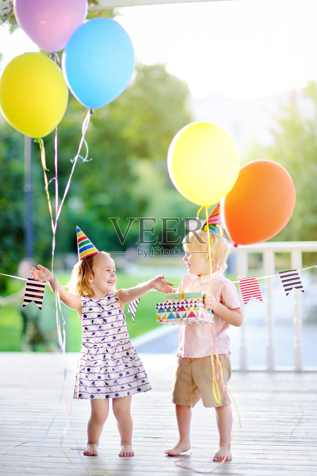 小男孩和小女孩玩得很开心，用彩色气球庆祝生日派对照片摄影图片