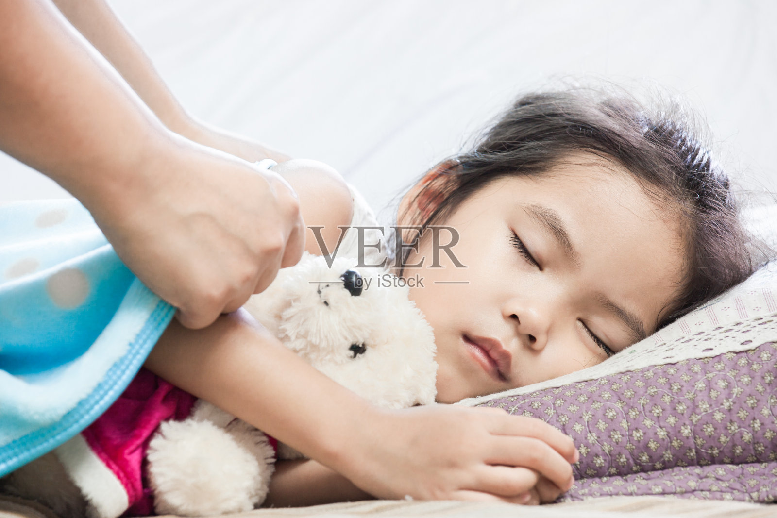 母亲照顾在床上睡觉的亚洲女孩照片摄影图片