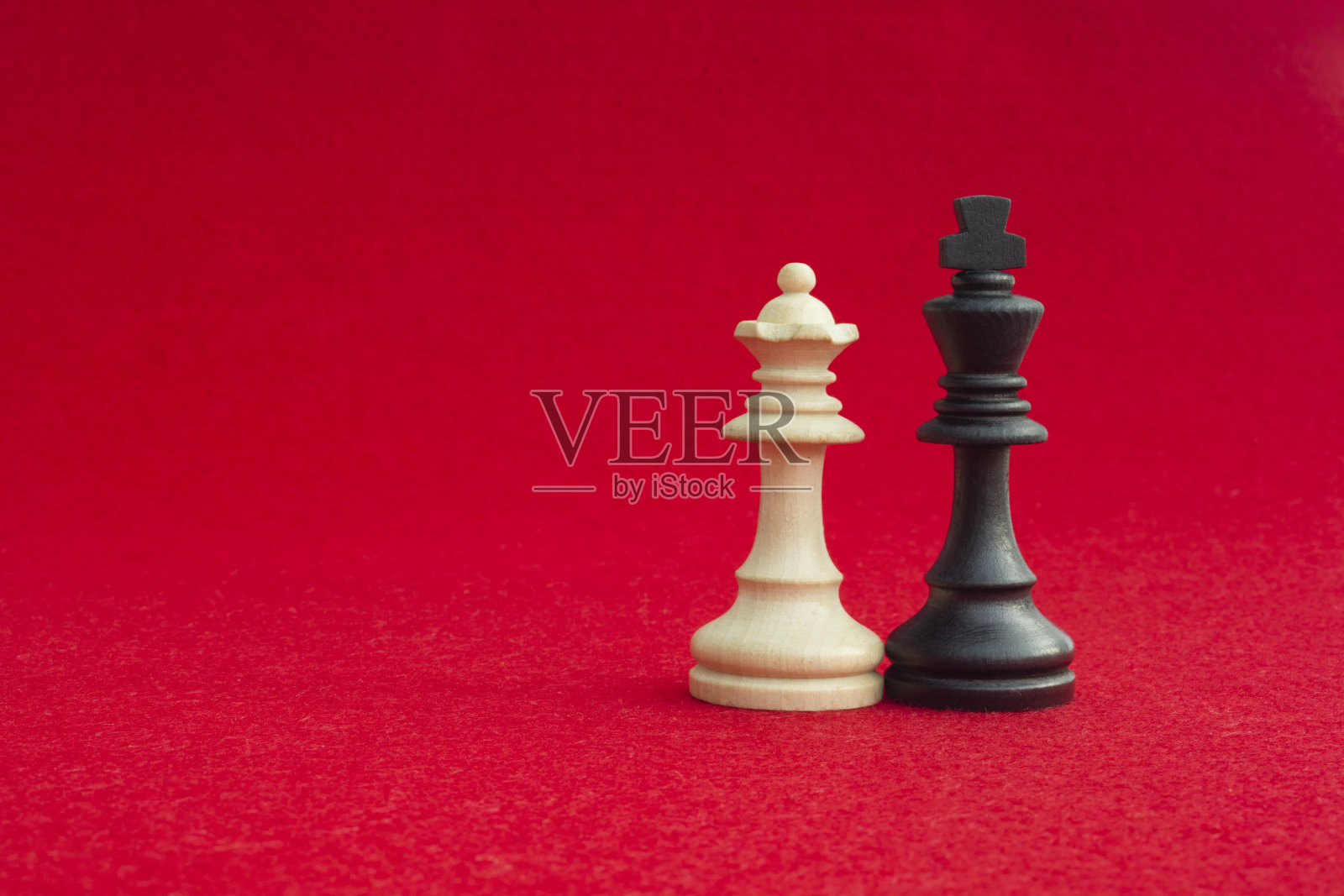 传统的国际象棋比赛中，白皇后和黑国王已经和好了。图像在孤立的红色背景照片摄影图片