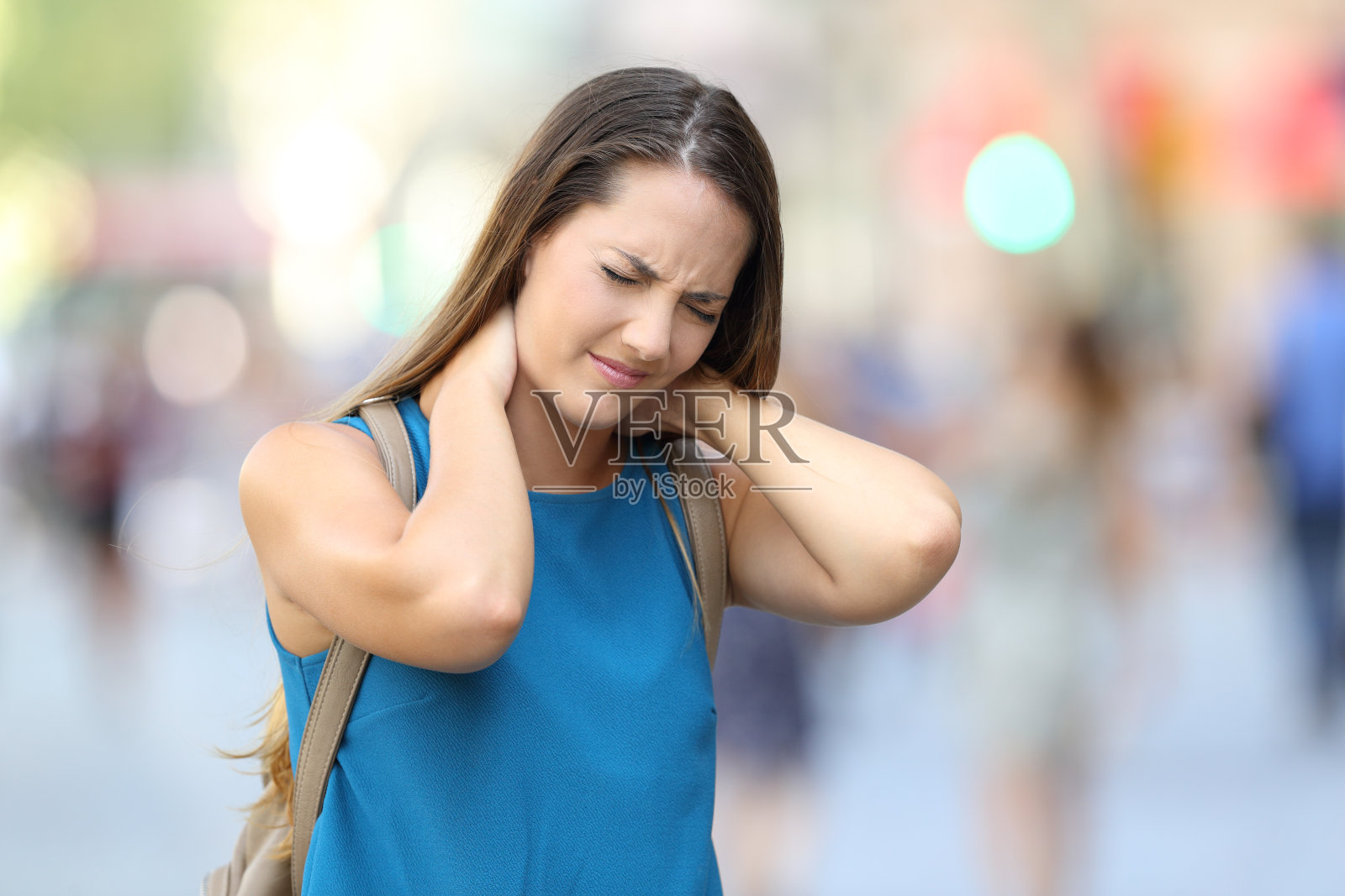 一个女人在街上脖子疼照片摄影图片